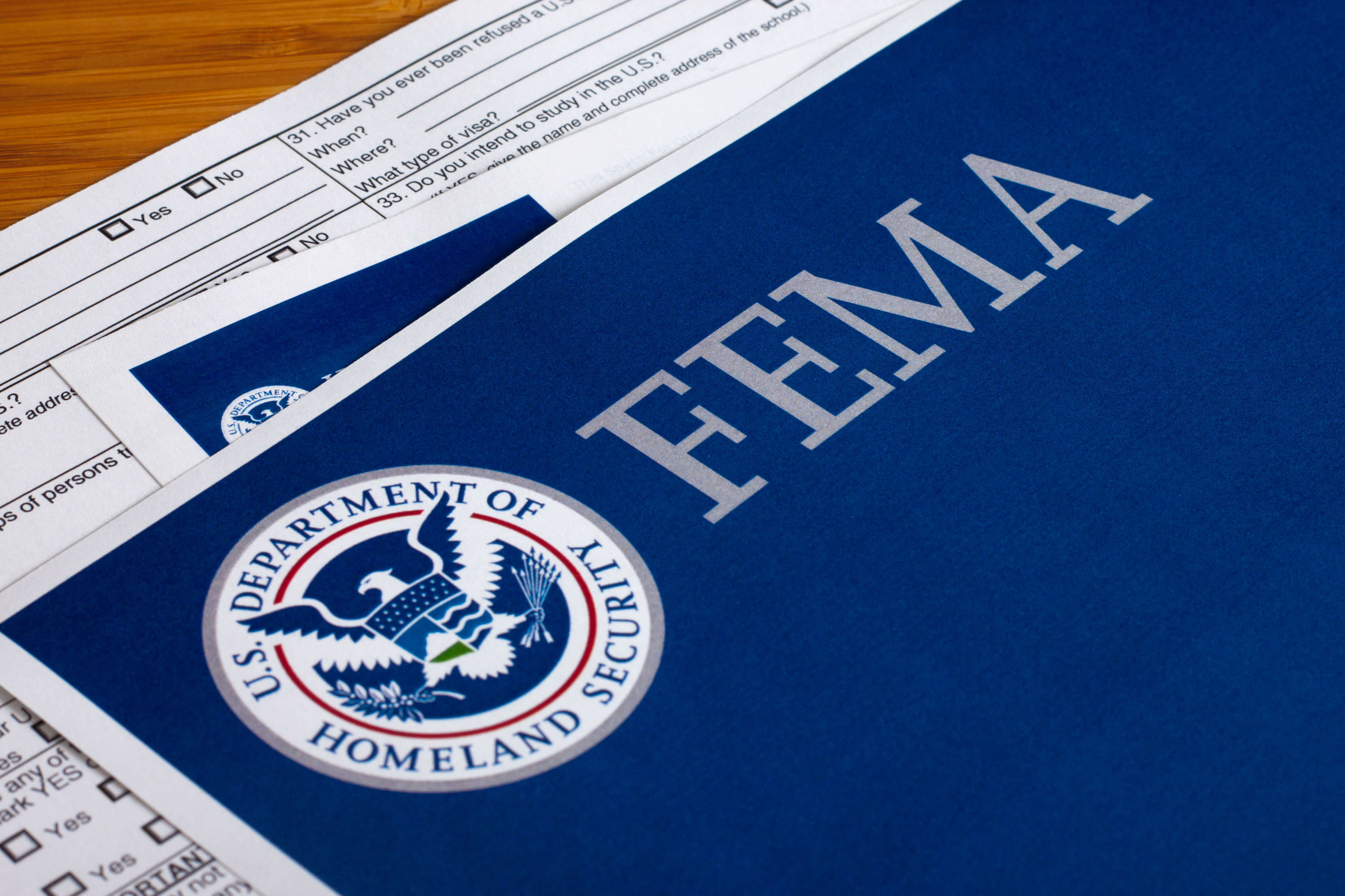 Documents stacked with the Federal Emergency Management Agency (FEMA) logo