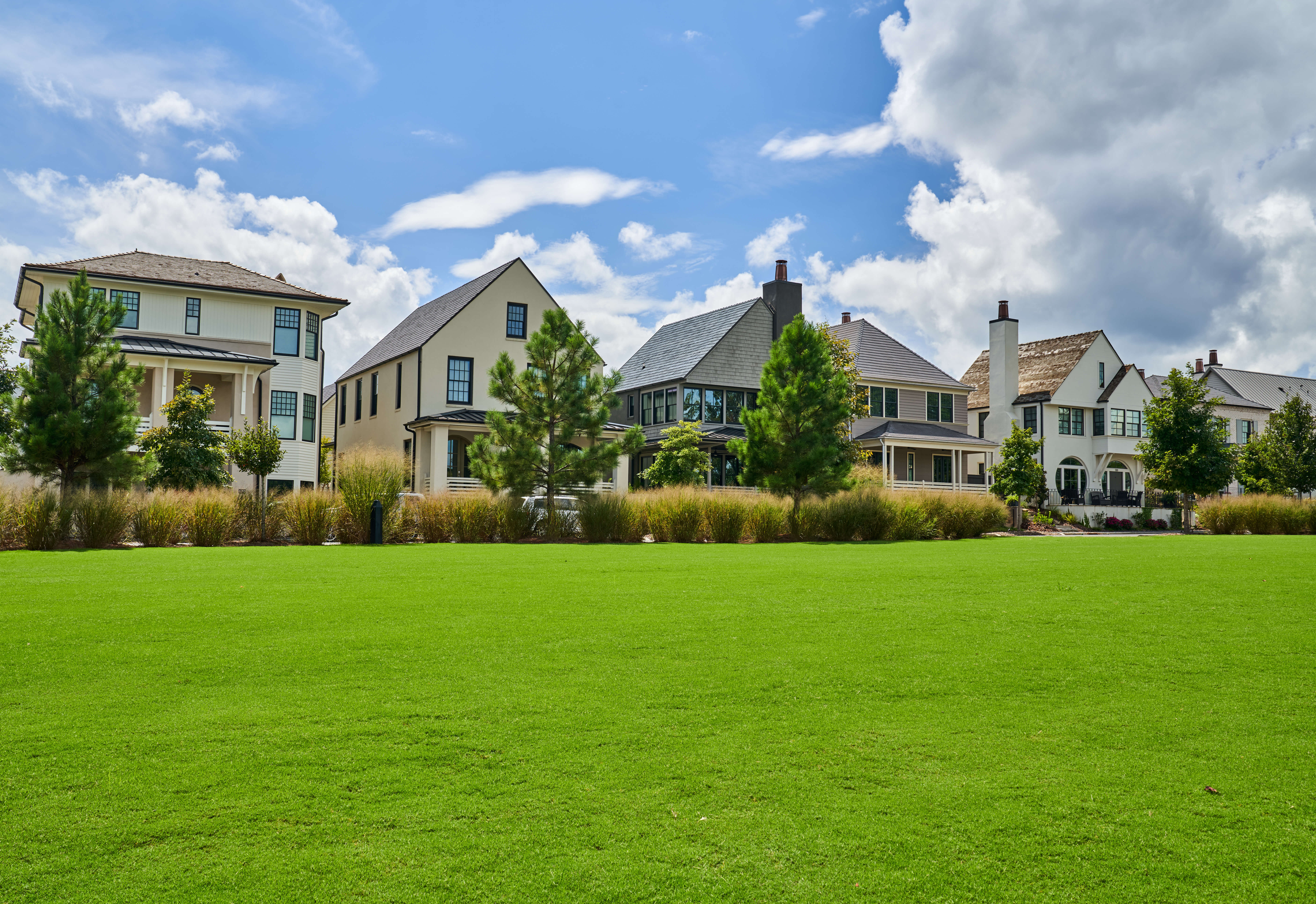 Row of modern suburban homes in Georgia under a bright blue sky, representing the protection offered through comprehensive Georgia homeowners insurance coverage