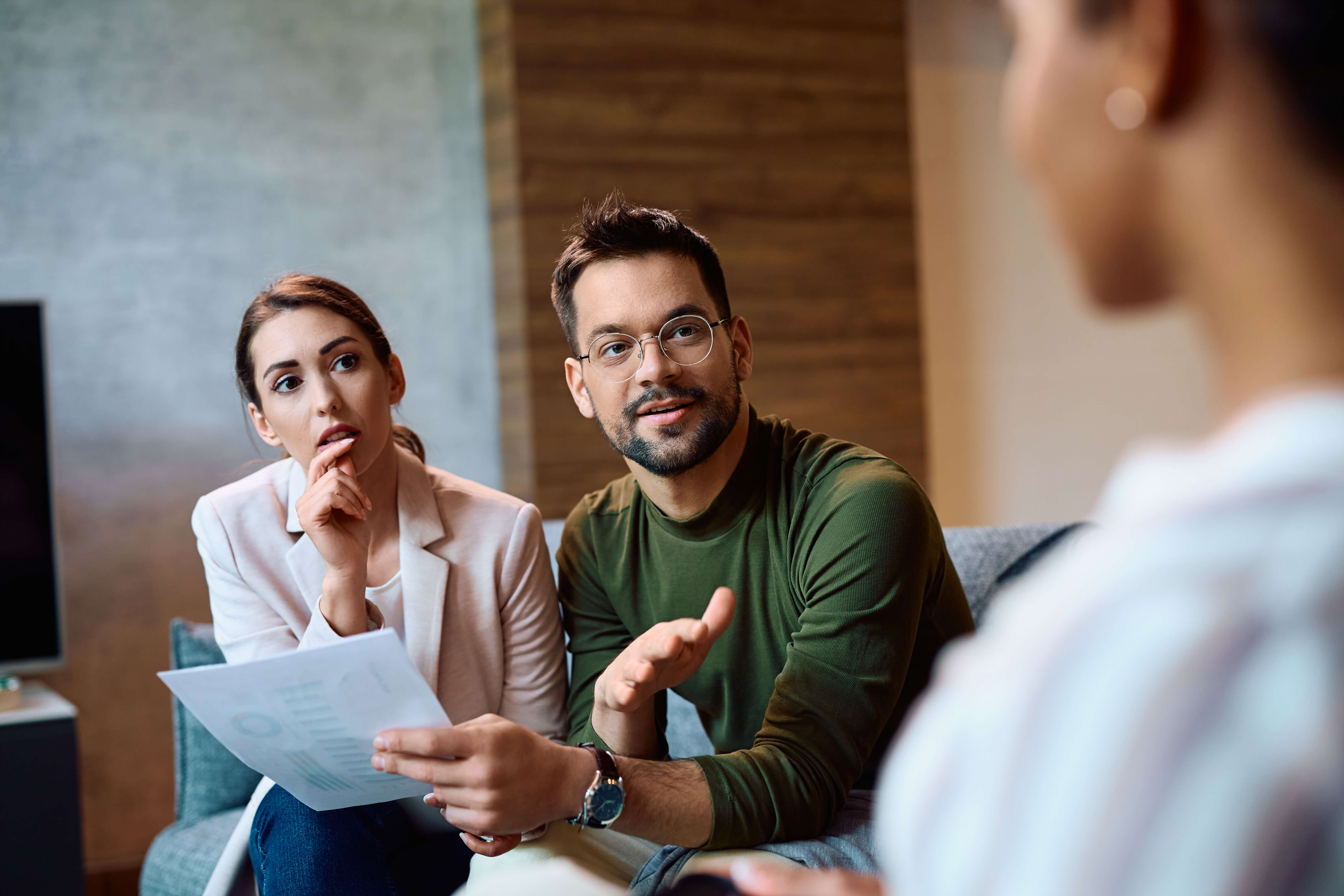 Couple discussing paperwork with an insurance adjuster, symbolizing the importance of understanding insurance claims and getting guidance throughout the process.
