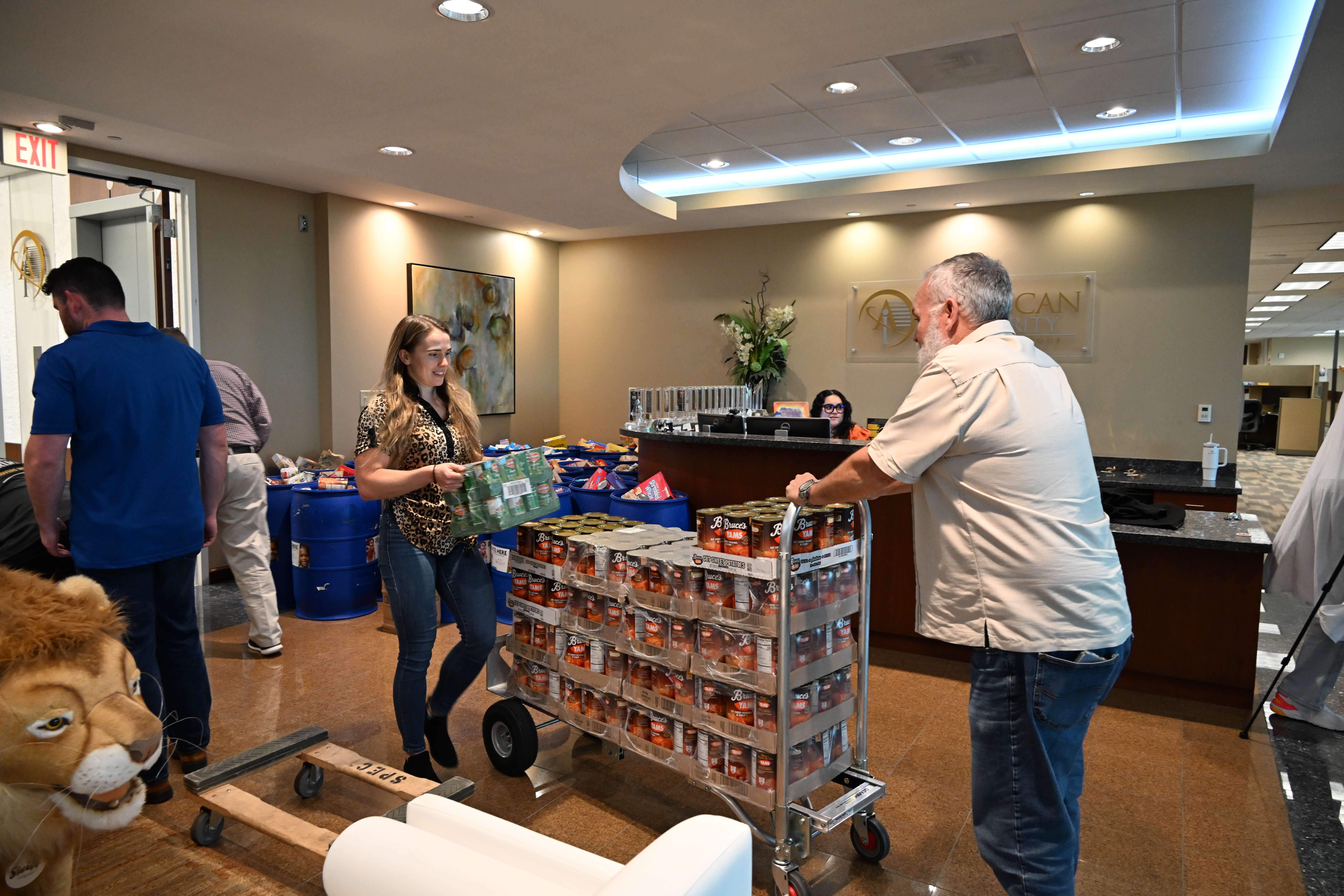 Members of the HR team unload bulk cans of yams to be donated to Metropolitan Ministries
